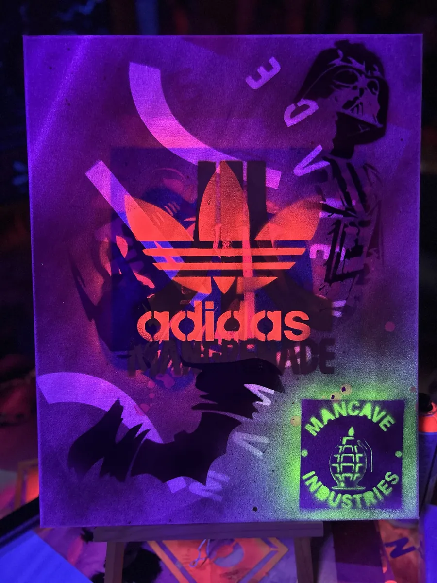 Layered stencils, helmet and seal on violet, under blacklight