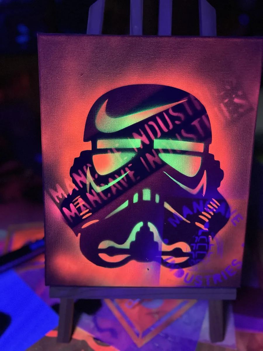 Trooper helmet over hot orange, crossed with Mancave Industries tape, under blacklight