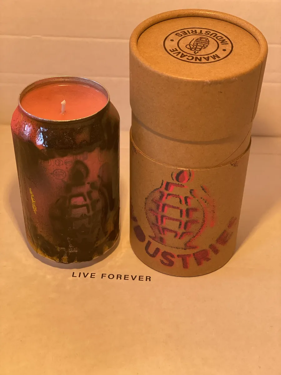 Black and red sprayed can candle next to its stamped kraft tube