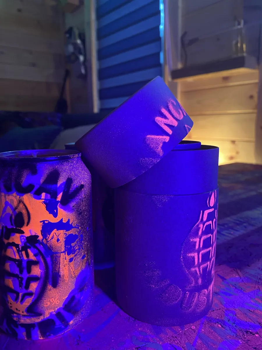 Two Mangrenades with red and green grenade stencils glowing under UV