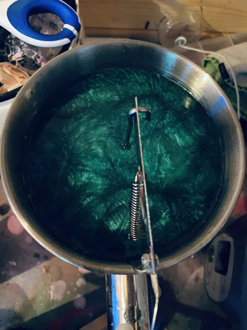 Pan of melted shimmering green wax